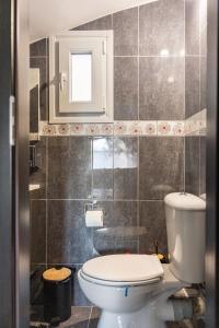 a bathroom with a toilet and a window at The travellers's house in Chalkida +17 photos