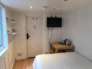 a bedroom with a bed and a desk and a door at Motel Schmotel in Brighton & Hove