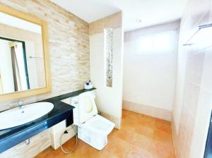 a bathroom with a sink and a toilet and a mirror at Sea Hill Hotel Bangsaray in Bang Sare