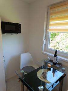 "ハルカーニャ"にあるHarka Central Apartmanのガラスのテーブルと窓が備わる客室です。