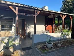 a house with two potted plants in front of it at Bungalow Jersleber See bei Magdeburg in Wolmirstedt