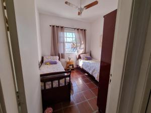 a small room with two beds and a window at Casa - Águas de São Pedro in Águas de São Pedro +50 photos