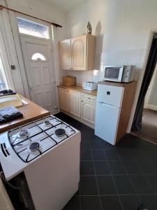 una cucina con fornelli e frigorifero bianco di Phoenix Nest a Skegness