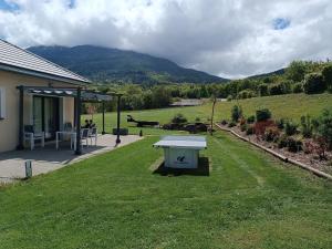 a picnic table in the grass next to a house at Magnifique Villa Sabot de Venus in Le Lautaret