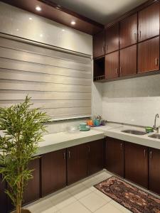 a kitchen with wooden cabinets and a sink at Galaxy Guest Home by Ipoh Maju Stay in Ipoh