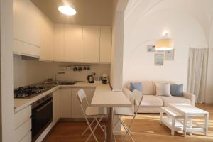 a kitchen and living room with a table and a couch at "CasaMia" Apartment - Brindisi Historic Center in Brindisi
