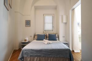 a bedroom with a bed with blue pillows and a window at "CasaMia" Apartment - Brindisi Historic Center in Brindisi