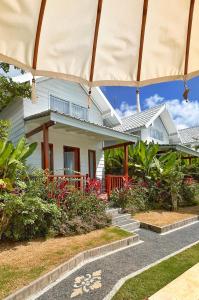 a house with a garden and an umbrella at Bacana Bungalow in Uluwatu
