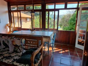 a dining room with a table and some windows at Casa - Águas de São Pedro in Águas de São Pedro