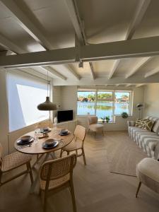 a living room with a table and a couch at Stillwater Lodge De Rijd in Nieuwe-Niedorp