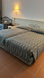 a bedroom with two beds with a bedspread on it at Domina coral bay resort direct beach and lake 1 in Sharm El Sheikh