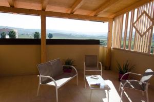 a room with chairs and a table and a large window at Civico 44 in Crotone