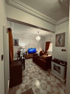 a living room with a couch and a tv at Cozy Apartment In East Legon Room 4008 in Accra