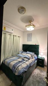 a bedroom with a bed and a clock on the ceiling at Cozy Apartment In East Legon Room 4008 in Accra