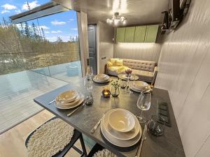 a dining room with a table with plates and wine glasses at Fela Mirror Cabin Designer Hideaway 1000 m Above Sea Level in Aurdal