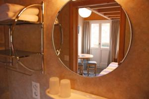 a bathroom mirror with a sink and a table at Hotel Alpenblick in Grindelwald