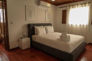 a bedroom with a bed with a teddy bear on it at Casa Da Formiga in Juncal de Cima +36 photos