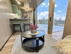 a living room with a table and a kitchen at Fela Mirror Cabin Designer Hideaway 1000 m Above Sea Level in Aurdal