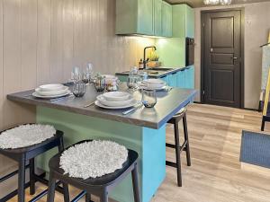 a kitchen with a table with plates and glasses on it at Fela Mirror Cabin Designer Hideaway 1000 m Above Sea Level in Aurdal