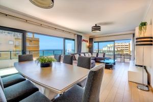 a living room with a table and chairs and a couch at Sunscape Rocha Prime - Oceanview - WiFi - Parking in Portimão