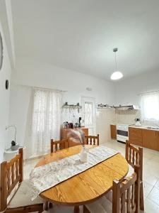 a kitchen and dining room with a wooden table and chairs at Seaside escape in Symi