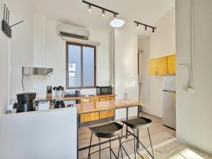 eine Küche mit einer Theke und 2 Hockern in der Unterkunft Donovan By Wynwood House in Panama-Stadt