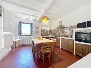 a kitchen with a table and chairs in a room at Casa Belvedere di Bolgheri in Bolgheri