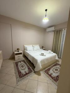 サランダにあるEleanas Apartamentのベッドルーム1室(白いベッド1台、ラグ2枚付)