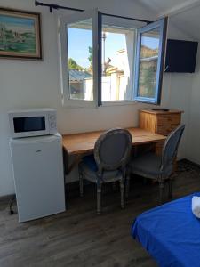 a room with a table and two chairs and a microwave at Studio indépendant in Le Pontet