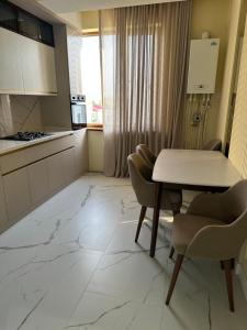 une cuisine avec une table, deux chaises et une table dans l'établissement Новая квартира с евро ремонтом, à Samarcande