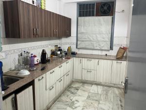 a kitchen with wooden cabinets and a tile floor at Golden Triangle in Jāmb
