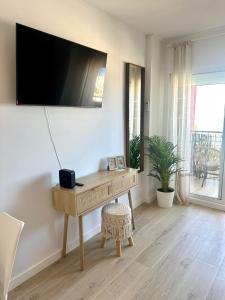 a desk in a room with a tv on a wall at Apartamento JÚPITER Vistas in Benalmádena