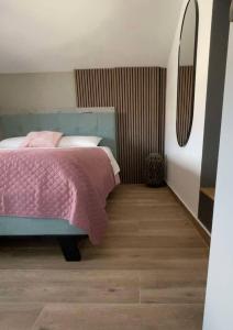 a bedroom with a bed with a pink blanket at Kalypso House in Nea Skioni