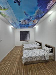 Habitación con 3 camas y una pintura en el techo. en well apartment, en Samarkand
