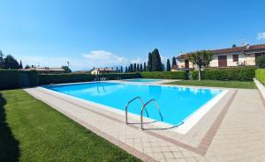 una gran piscina en un patio con césped en Residence sole del Garda, en Lazise