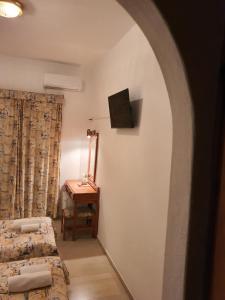 a room with two beds and a table and a window at Panorama Hotel in Agios Stefanos