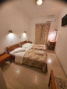 a bedroom with a large bed and a window at Panorama Hotel in Agios Stefanos