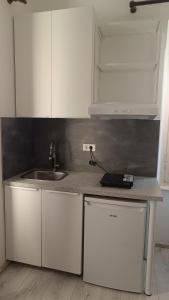 a kitchen with white cabinets and a sink at San Eleuterio Guesthouse in Poreč