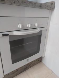 a white oven with a granite counter top in a kitchen at Apartamento Junto AL MAR Quesada 2 in Almería
