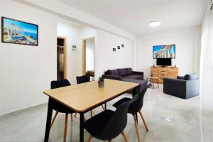 a living room with a wooden table and chairs at Stasia Apartment in Nikiti