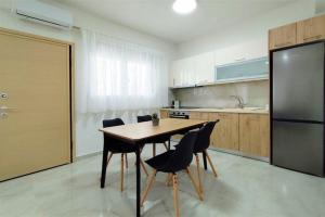 a kitchen with a table and chairs and a refrigerator at Stasia Apartment in Nikiti +10 photos