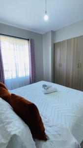 a bedroom with a large white bed with a window at Chiq 1 bedroom for short and long stay accomodation - Ruiru Astrol Apartments in Ruiru