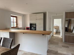 a kitchen with white walls and a wooden counter top at 2 gîtes à la campagne, proche mer, 18 personnes in Landévant