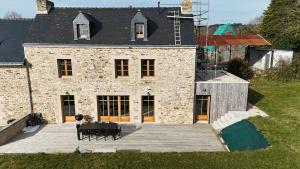 an aerial view of a stone house with a patio at 2 gîtes à la campagne, proche mer, 18 personnes in Landévant +2 photos