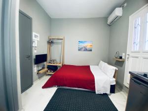 a bedroom with a bed with a red and white blanket at The Central Retreat 4 in Mytilini