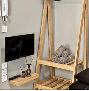 a wooden shelf with a flat screen tv and towels at The Central Retreat 4 in Mytilene