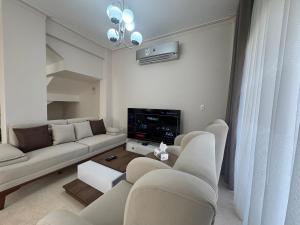 a living room with a couch and a tv at Villa Mountain View 4 October in ‘Ezbet `Abd el-Ḥamîd