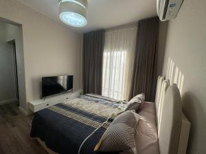 a bedroom with a bed and a flat screen tv at Villa Mountain View 4 October in ‘Ezbet `Abd el-Ḥamîd