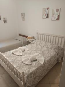 a bed with two hats and towels on it at Airport Anasta Casa in Artemida