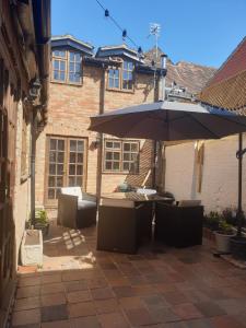 a patio with a table and an umbrella at St Cuthbert's Keep in Bedford